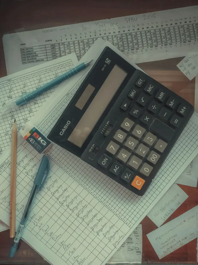 a calculator sitting on top of a pile of papers